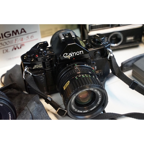 329 - Quantity of cameras to include Canon A-1 fitted with 35mm zoom lens, together with kodak, sigma, can... 