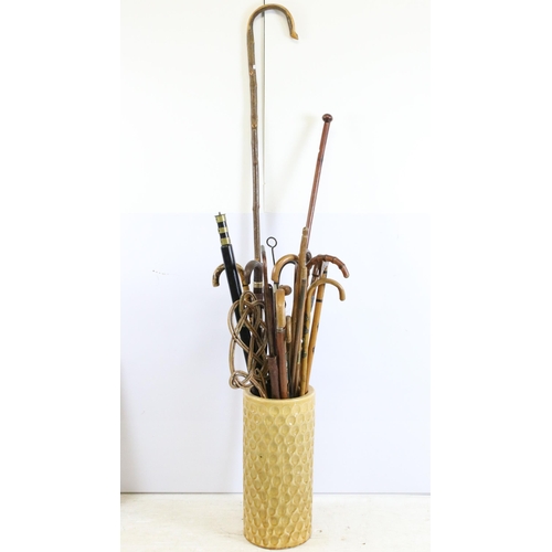 122 - large ceramic umbrella stick stand together with a large quantity of walking sticks in varying forms... 