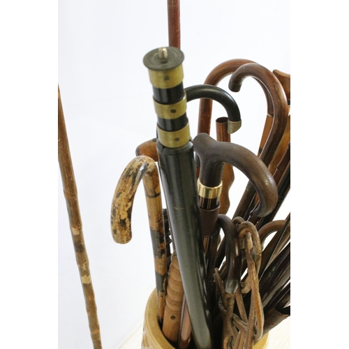 122 - large ceramic umbrella stick stand together with a large quantity of walking sticks in varying forms... 