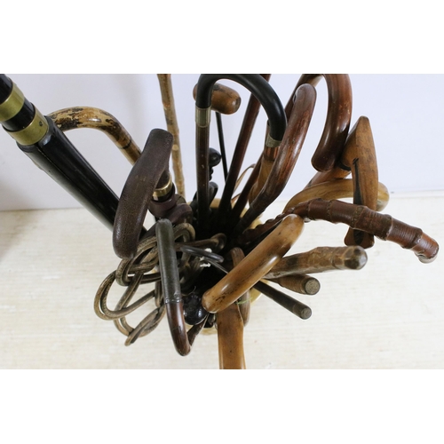 122 - large ceramic umbrella stick stand together with a large quantity of walking sticks in varying forms... 