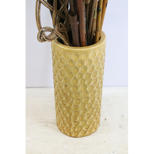 122 - large ceramic umbrella stick stand together with a large quantity of walking sticks in varying forms... 