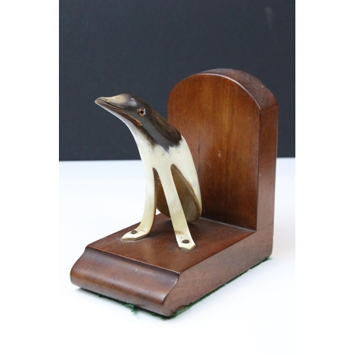 133 - Art Deco mahogany bookends, each set with a horn penguin, 15cm