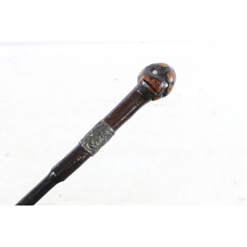 163 - Three 20th century wooden walking stick canes one carved head example with jewelled eyes and silver ... 