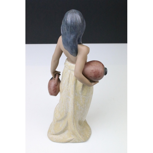 17 - Lladro Water Girl, No 2323, modelled as a semi nude girl carrying a jug and vessel in matte finish, ... 