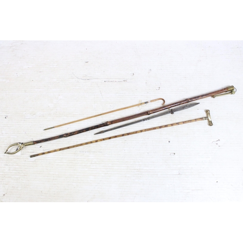 180 - Group of four bamboo walking stick canes to include one metal spiked example and a brass ended reach... 