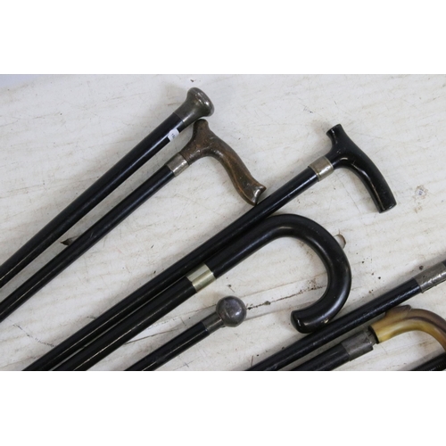 189 - Assorted ebonised wood walking stick canes with silver and horn handle examples and a riding crop