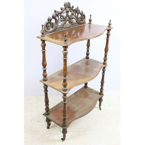 635 - Late 19th / early 20th century mahogany three tier whatnot, with intricately carved pediment, above ... 