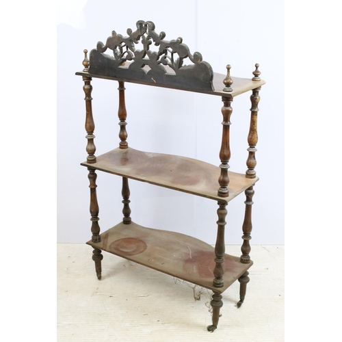 635 - Late 19th / early 20th century mahogany three tier whatnot, with intricately carved pediment, above ... 