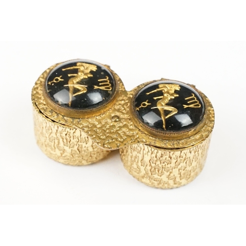 194 - Mid century gilt metal double pill or cufflink box, each lid decorated with an erotic lady and zodia... 