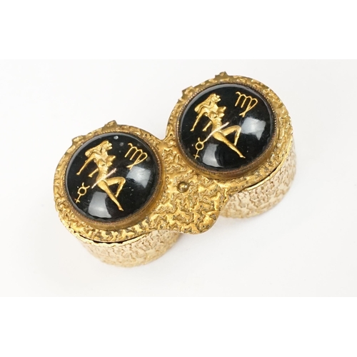 194 - Mid century gilt metal double pill or cufflink box, each lid decorated with an erotic lady and zodia... 