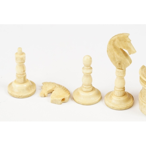 209 - A collection of 19th century carved bone chessmen within a vintage tin.