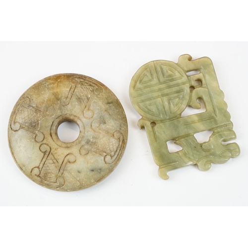 210 - A collection of twenty three oriental carved jade and stone amulets of traditional form.