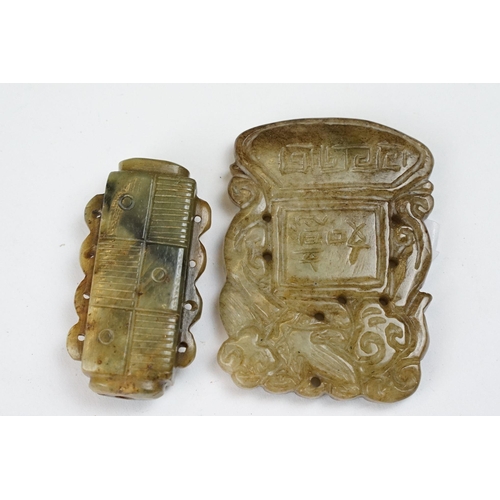 210 - A collection of twenty three oriental carved jade and stone amulets of traditional form.