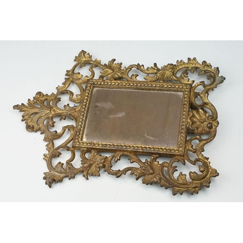 214 - Two early to mid 20th century gilt metal table mirrors with ornate floral decoration.