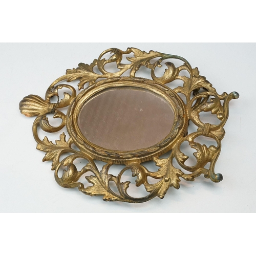 214 - Two early to mid 20th century gilt metal table mirrors with ornate floral decoration.