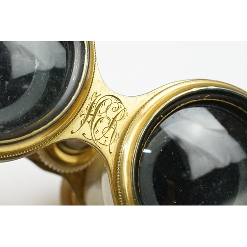 216 - A pair of gilt metal and mother of pearl multi purpose binoculars by Chevalier of Paris, three setti... 