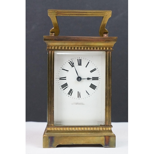 219 - An antique French brass cased carriage clock with bevelled glass panels, retailer marked for Gaydon ... 