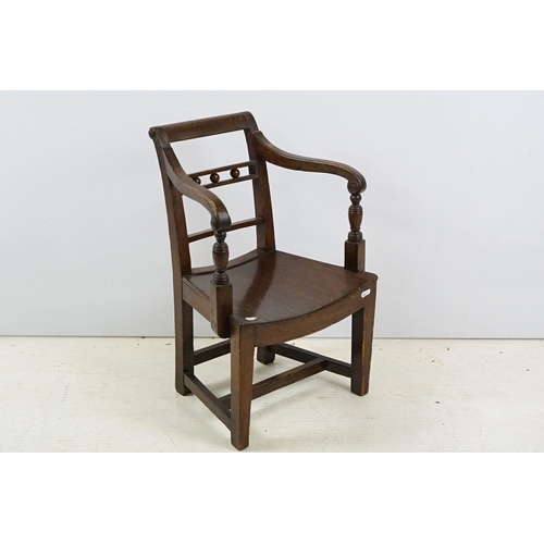 335 - 19th century mahogany child's chair with scroll arms, carved ball and bar back, curved solid seat on... 