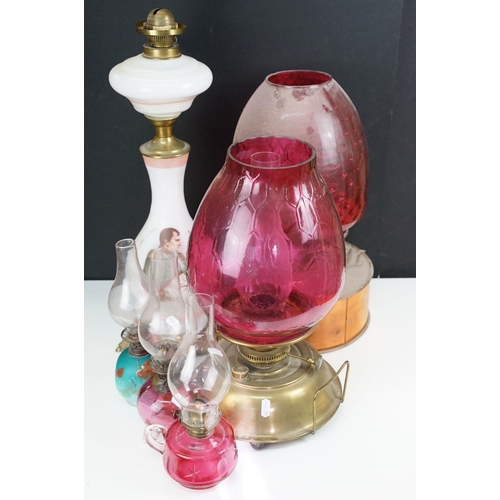 36 - Collection of Victorian oil lamps to include two large cranberry glass and clear chimney examples, t... 