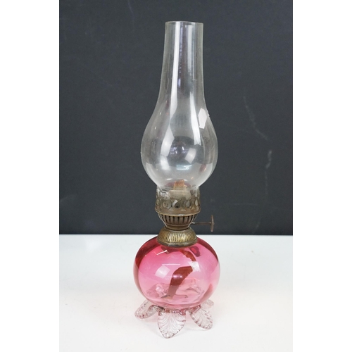 36 - Collection of Victorian oil lamps to include two large cranberry glass and clear chimney examples, t... 