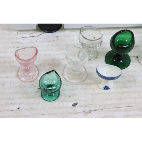 427 - Large collection of antique and vintage mixed coloured and shape glass eye baths to include milk gla... 