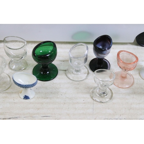 427 - Large collection of antique and vintage mixed coloured and shape glass eye baths to include milk gla... 