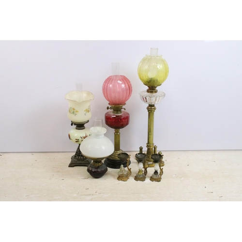 430 - Group of four Victorian oil lamps to include cranberry glass, brass based, white glass shade and flo... 