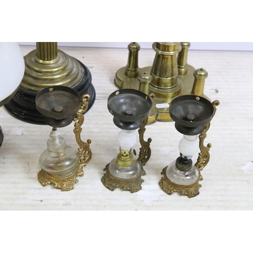 430 - Group of four Victorian oil lamps to include cranberry glass, brass based, white glass shade and flo... 