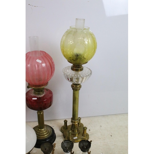 430 - Group of four Victorian oil lamps to include cranberry glass, brass based, white glass shade and flo... 