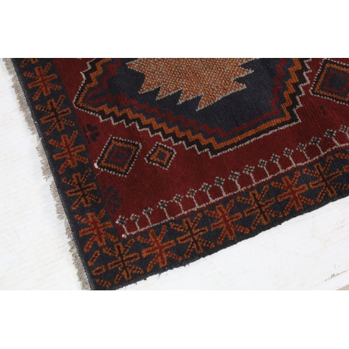 697A - Middle Eastern baluchi carpet rug having a red ground with two geometric medallions to central panel... 