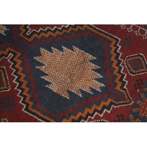 697A - Middle Eastern baluchi carpet rug having a red ground with two geometric medallions to central panel... 