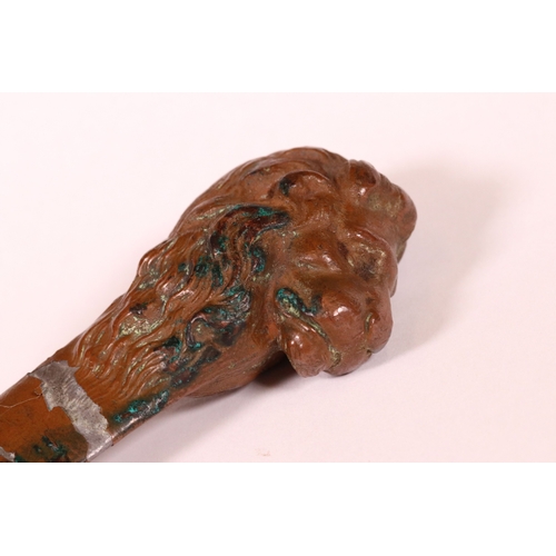 219 - 18th  or 19th century lead page turner with a bronze finish, the handle cast in the form of a a lion... 