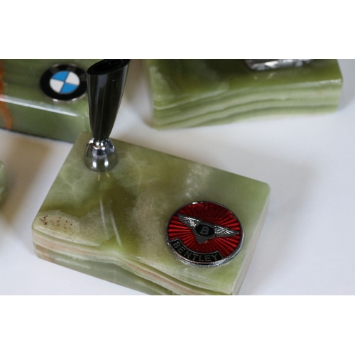 236 - A collection of six desk top pen holders, green agate bases adorned with car makers badges to includ... 