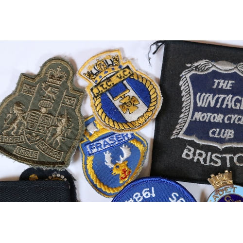 240 - A collection of badges and cloth patches to include Motorcycle, Military and Sports interest.