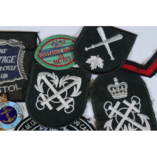 240 - A collection of badges and cloth patches to include Motorcycle, Military and Sports interest.