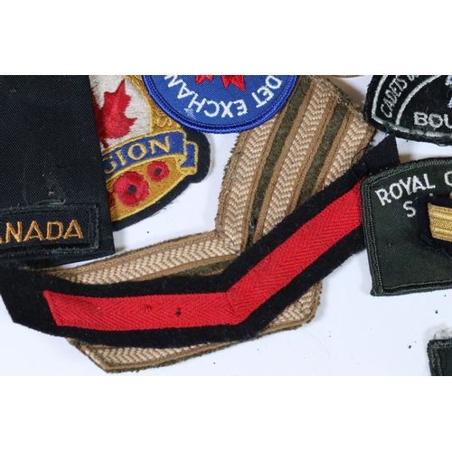 240 - A collection of badges and cloth patches to include Motorcycle, Military and Sports interest.