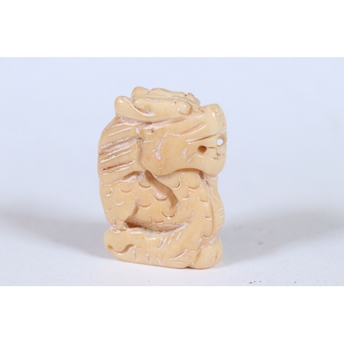 282 - Three bone miniature netsuke / figures to include Chinese dragon panel, Chinese Dragon and dogs head