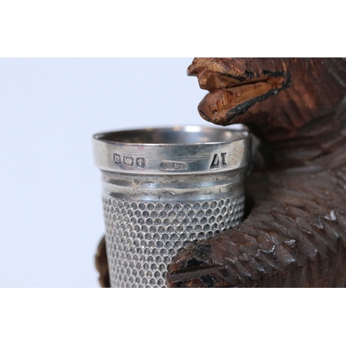 313 - A small black forest bear thimble holder complete with hallmarked silver thimble and scissors.