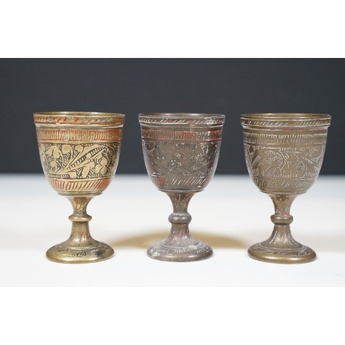 485 - Group of Indian style brass items to include goblets in varying sizes, cobra style candlesticks and ... 