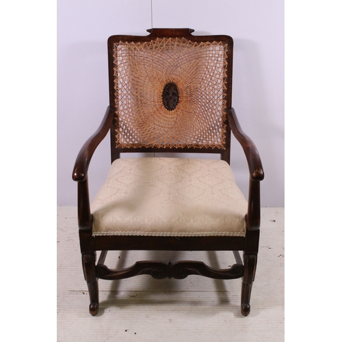 673 - Cane back fireside arm chair with carved central decoration, scroll detail and legs, H 87cm