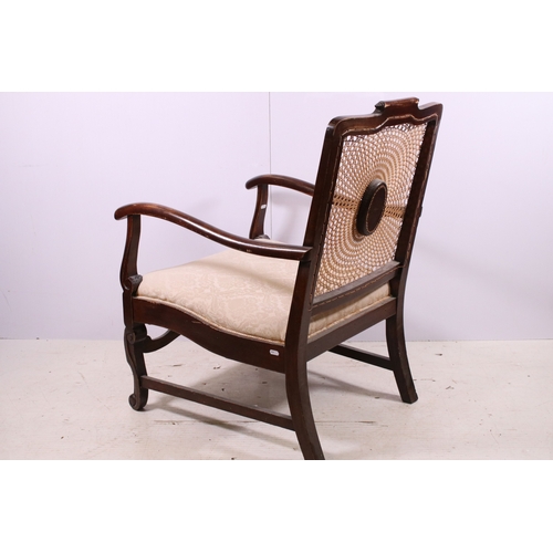 673 - Cane back fireside arm chair with carved central decoration, scroll detail and legs, H 87cm