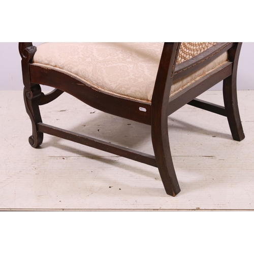 673 - Cane back fireside arm chair with carved central decoration, scroll detail and legs, H 87cm