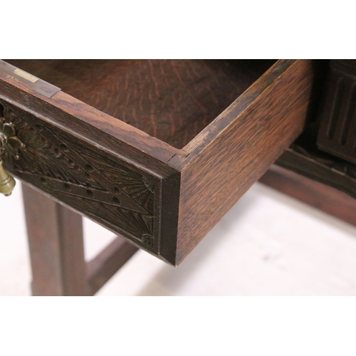 705 - Early 20th century carved top and front oak table with two drawers, H 76cm, W 93cm, D 53cm