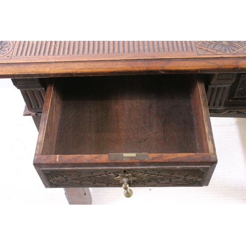 705 - Early 20th century carved top and front oak table with two drawers, H 76cm, W 93cm, D 53cm