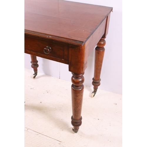 708 - Small single drawer mahogany table with turned legs and casters, H 75cm, W 67cm, D 53cm