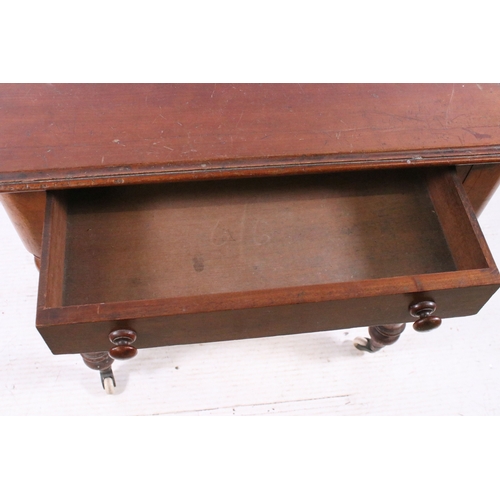 708 - Small single drawer mahogany table with turned legs and casters, H 75cm, W 67cm, D 53cm