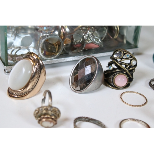 378 - A collection of costume jewellery rings within a glass paneled casket.