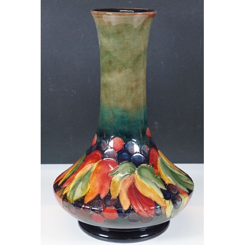 15 - Moorcroft tall compressed bottle form vase in 'Leaf and Berry' design, artist signed to base, stampe... 