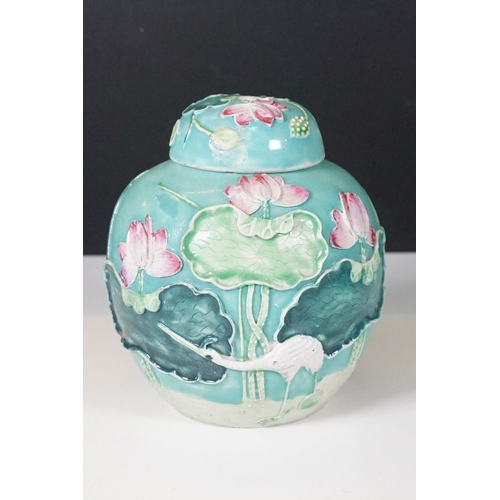 72 - 20th century green glazed lidded ginger jar with applied leaves, flowers and stork, standing on wood... 