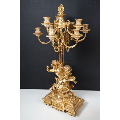 183 - Pair of large golden finish nine branch candelabras with winged cherub, beads, rams head and flame d... 